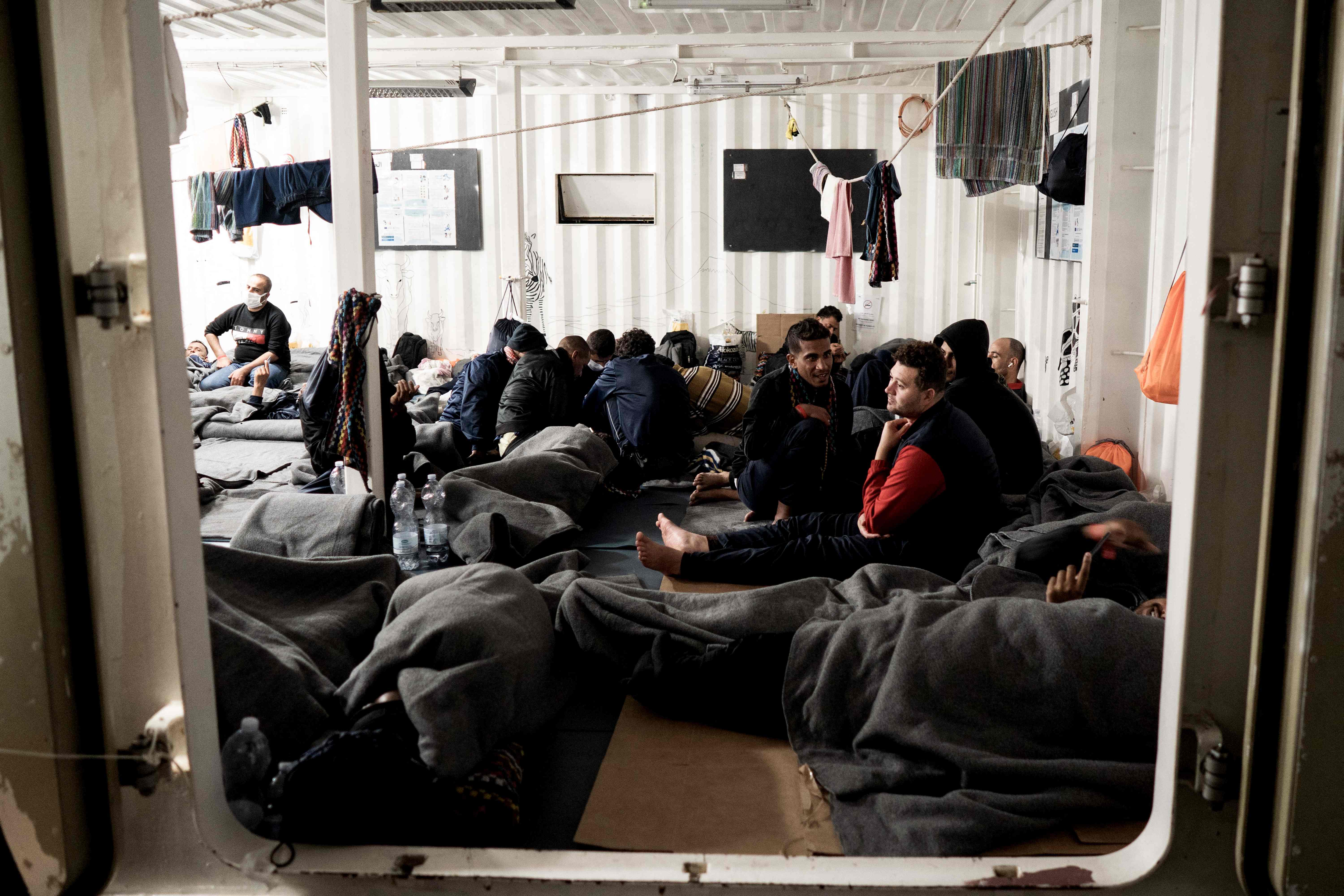 Migrants rest aboard the ‘Ocean Viking’ rescue ship in the Gulf of Catania on Sunday