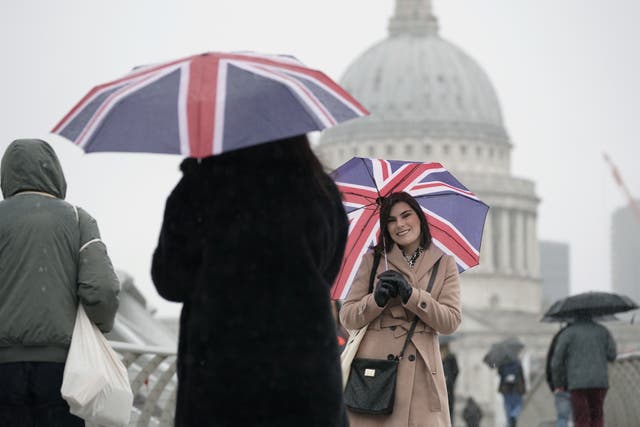 Two women holding Union Jack umbrellas during a rain shower, on the Millennium Bridge in London. Picture date: Monday November 7, 2022.