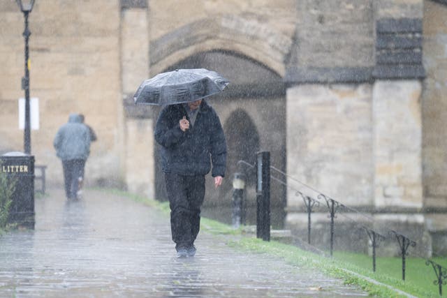 A man shelters under an umbrella as he walks in the rain near Wells Cathedral, Wells, Somerset. Picture date: Monday November 7, 2022.