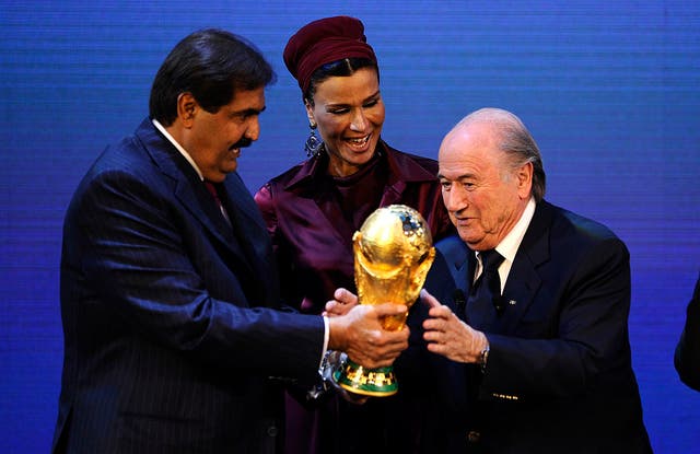<p>Sepp Blatter hands over the World Cup trophy to the Emir of Qatar Sheikh Hamad bin Khalifa Al-Thani in 2010</p>