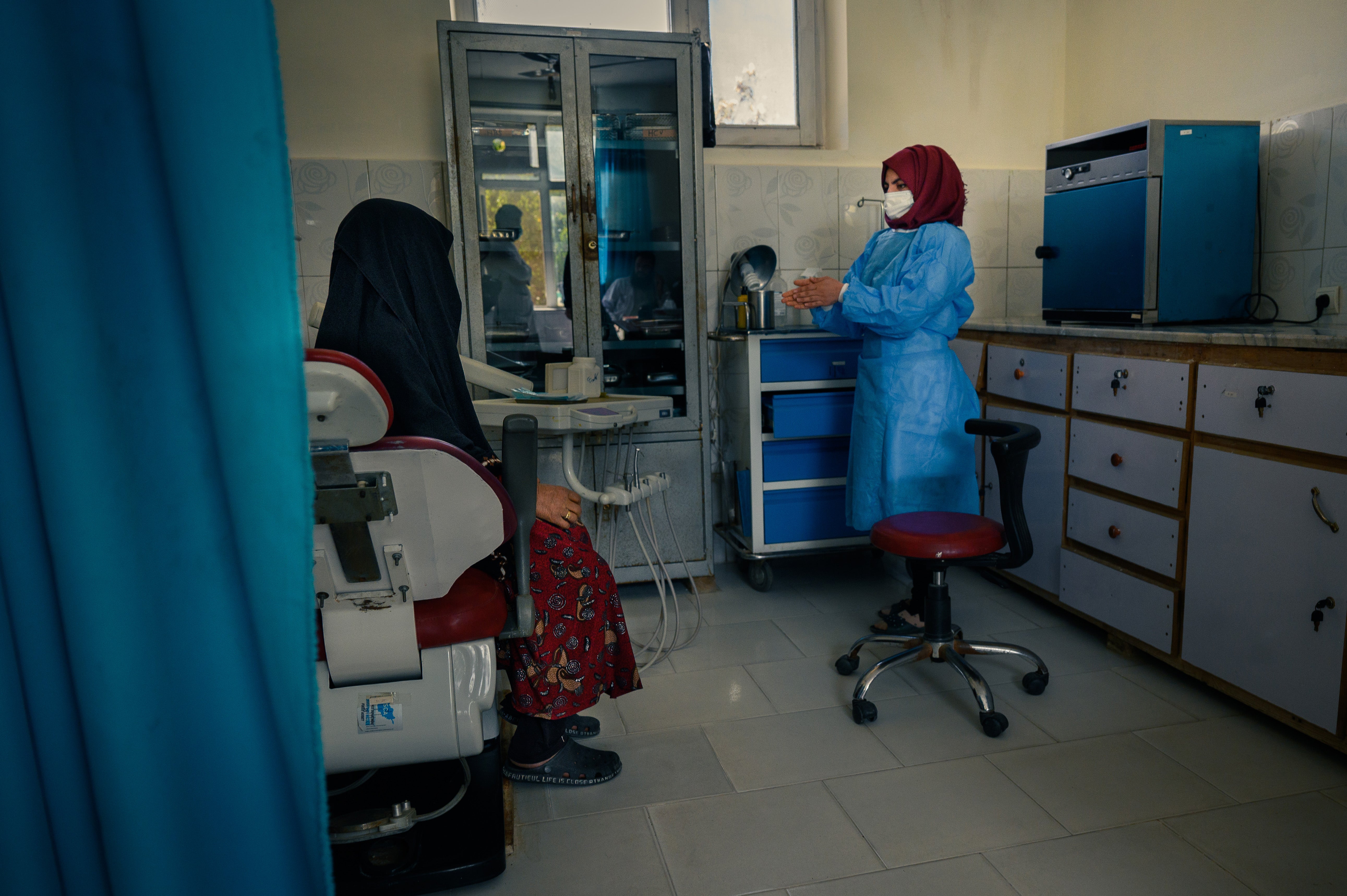 A dentist and graduate of Kabul University receives patients