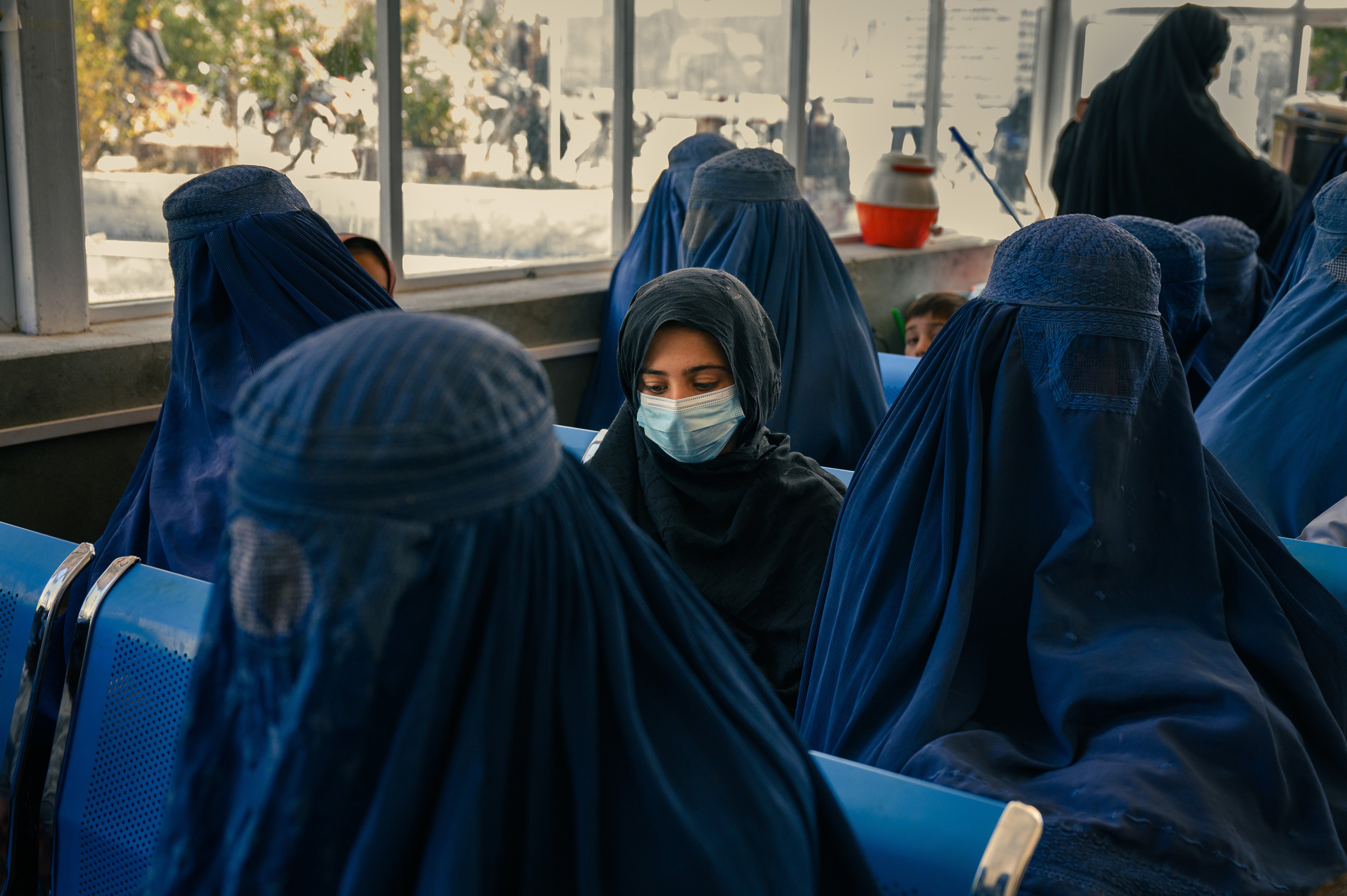 A girl and women sit in the waiting room of the paediatric outpatient department at the Maidan Shahr provincial hospital