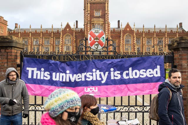 <p>UCU banner hangs from the gates of Queen’s University Belfast during strikes last February</p>