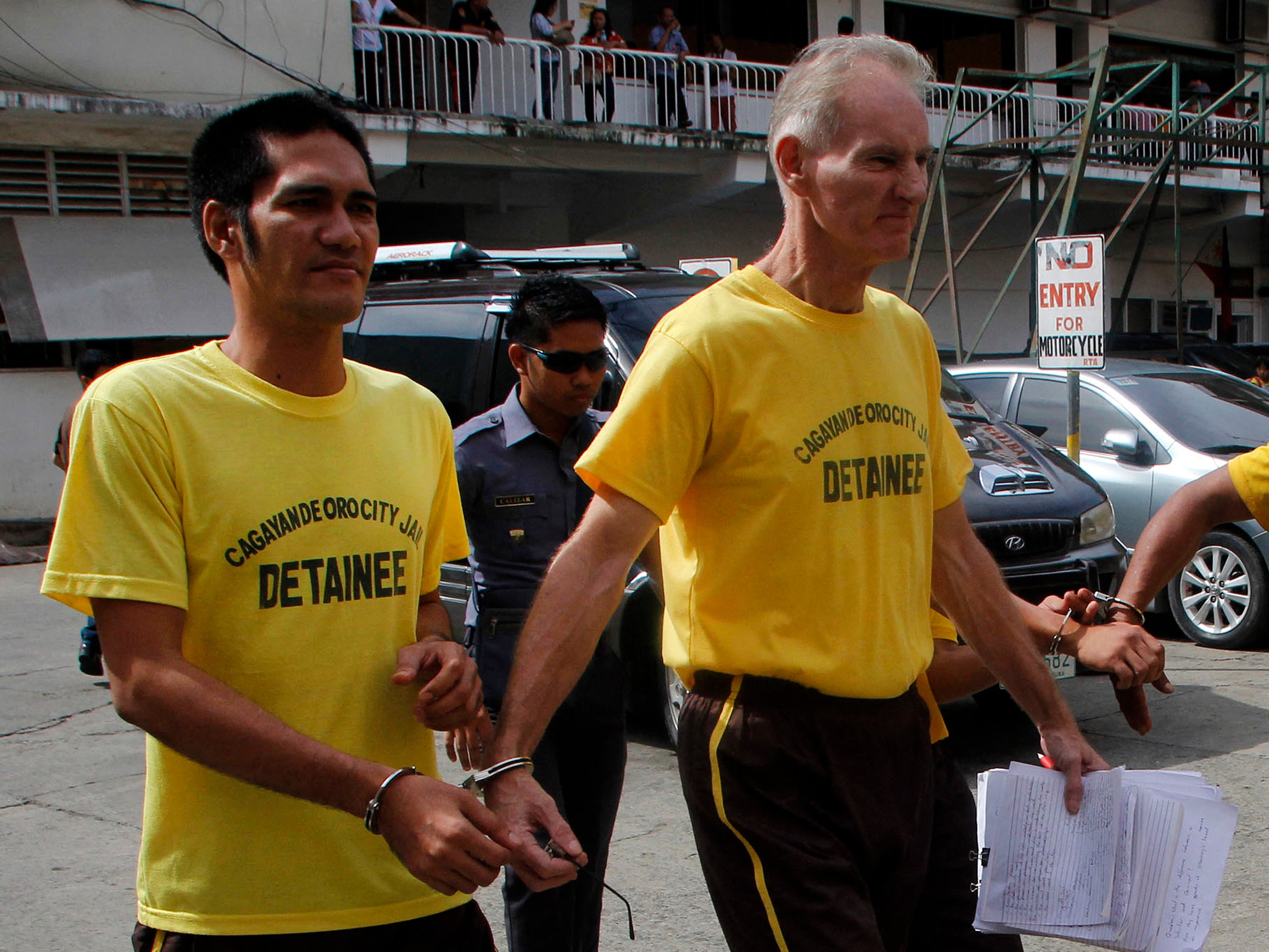 File. Peter Scully of Australia (R), accused of raping and trafficking two girls in the Philippines, leaves the court handcuffed to another inmate (L) after his arraignment in Cagayan de Oro City, on the southern Philippine island of Mindanao on June 16, 2015