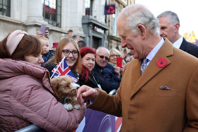 Charles is greeted by members of the public and a little dog as he arrives for a ceremony at Mansion House to confer city status on Doncaster (Molly Darlington/PA)