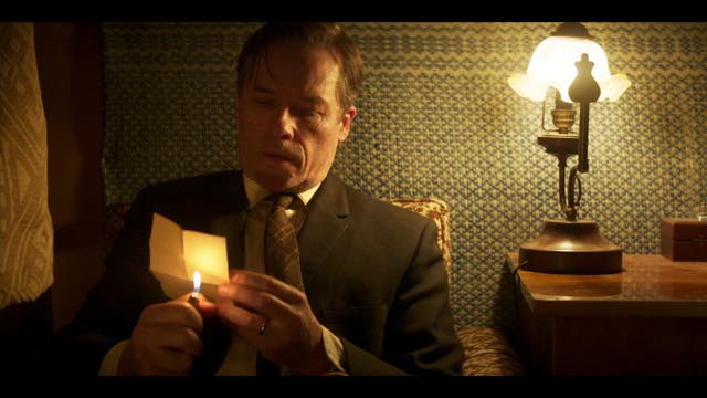 <p>In new ITVX drama <em>A Spy Among Friends</em>, tradecraft abounds. Here KGB spy Philby (Guy Pearce) heats up messages written in invisible ink so he can read them</p>