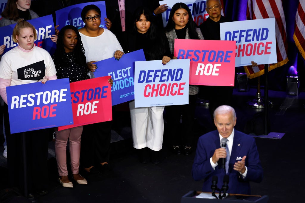 Women hold signs supporting the right to an abortion as Joe Biden speaks in Washington DC