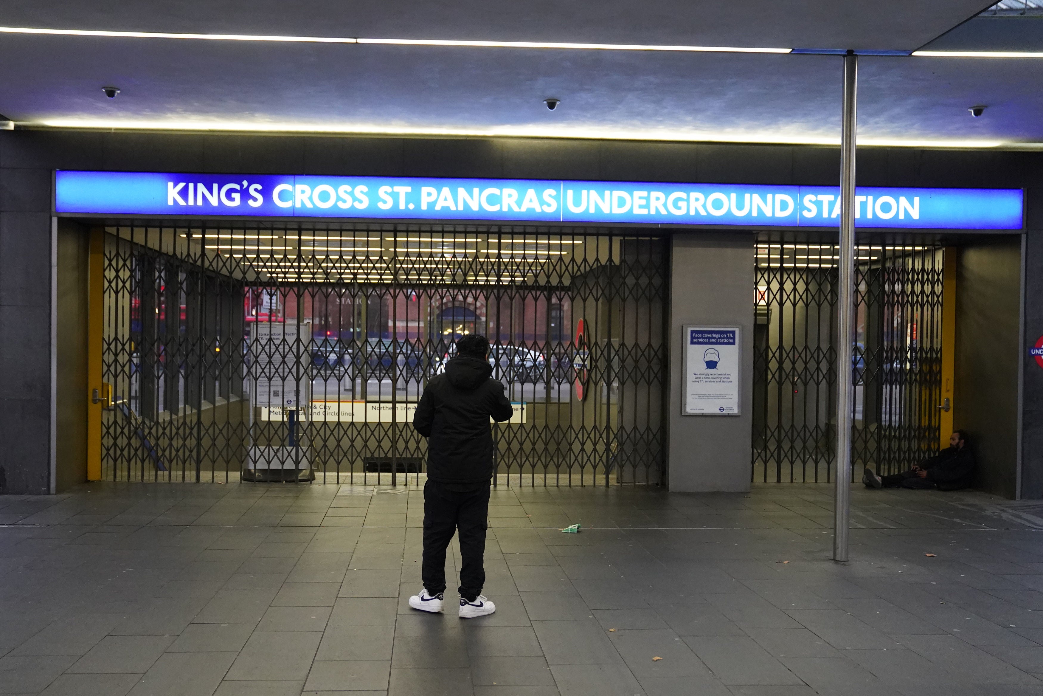 A man looks at the closed shutters at the entrance to King's Cross station in central London,