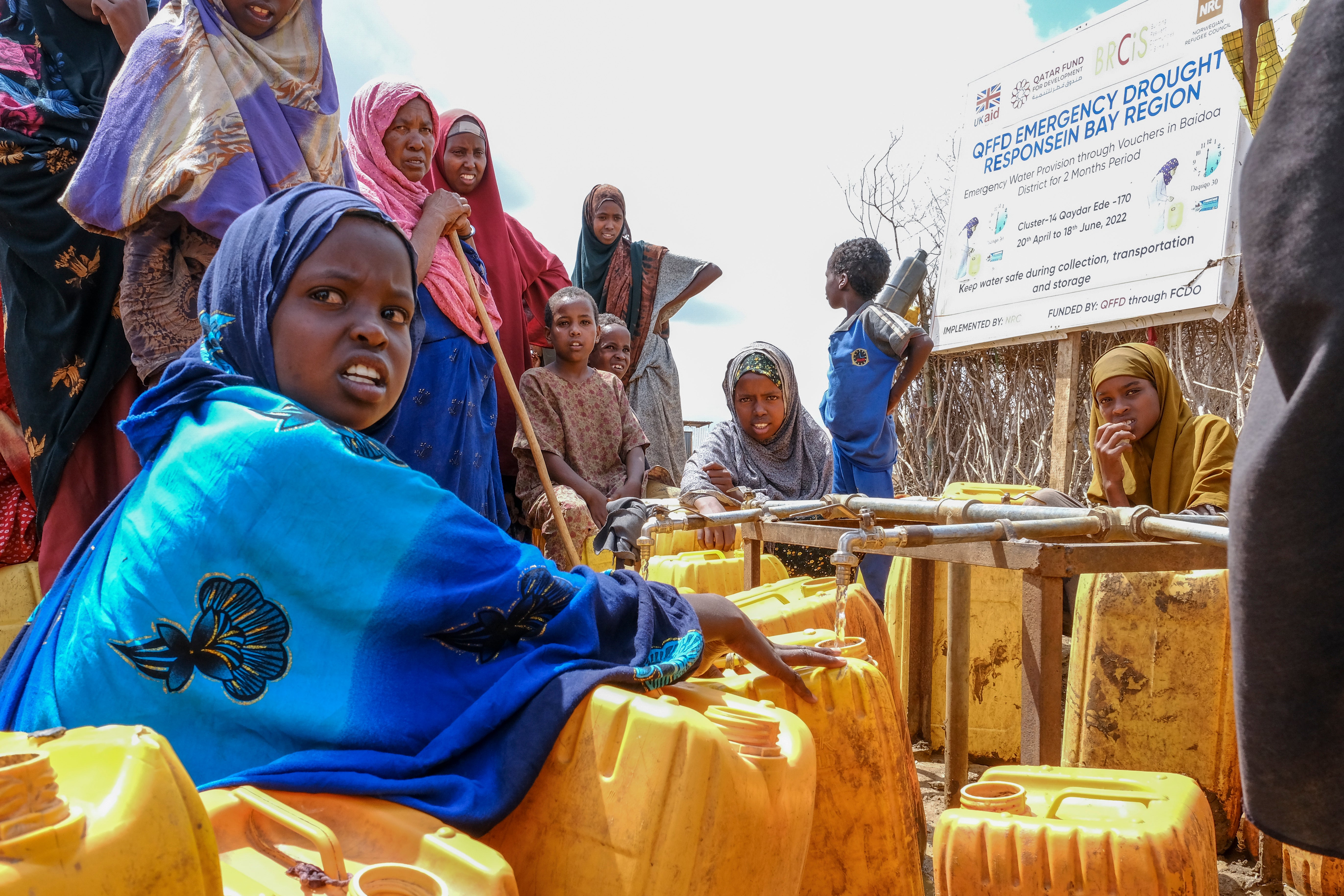 Isha Kerow, left, and other Somalis displaced by drought, fill jerrycans with water distributed by the Norwegian Refugee Council on the outskirts of Baidoa, Somalia, last month