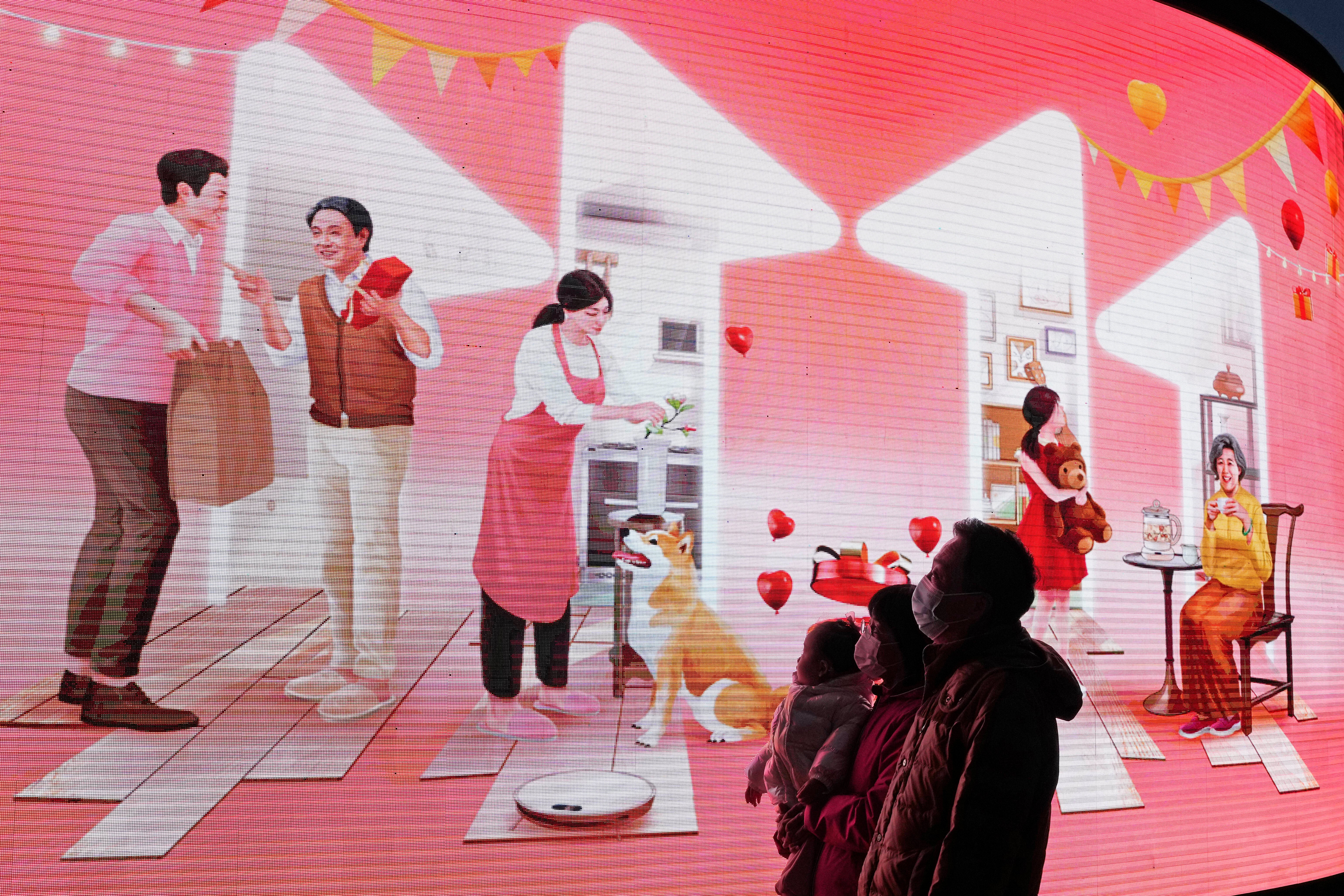 Shoppers look up at an ad for the online shopping festival ‘Singles’ Day’ in Beijing last week