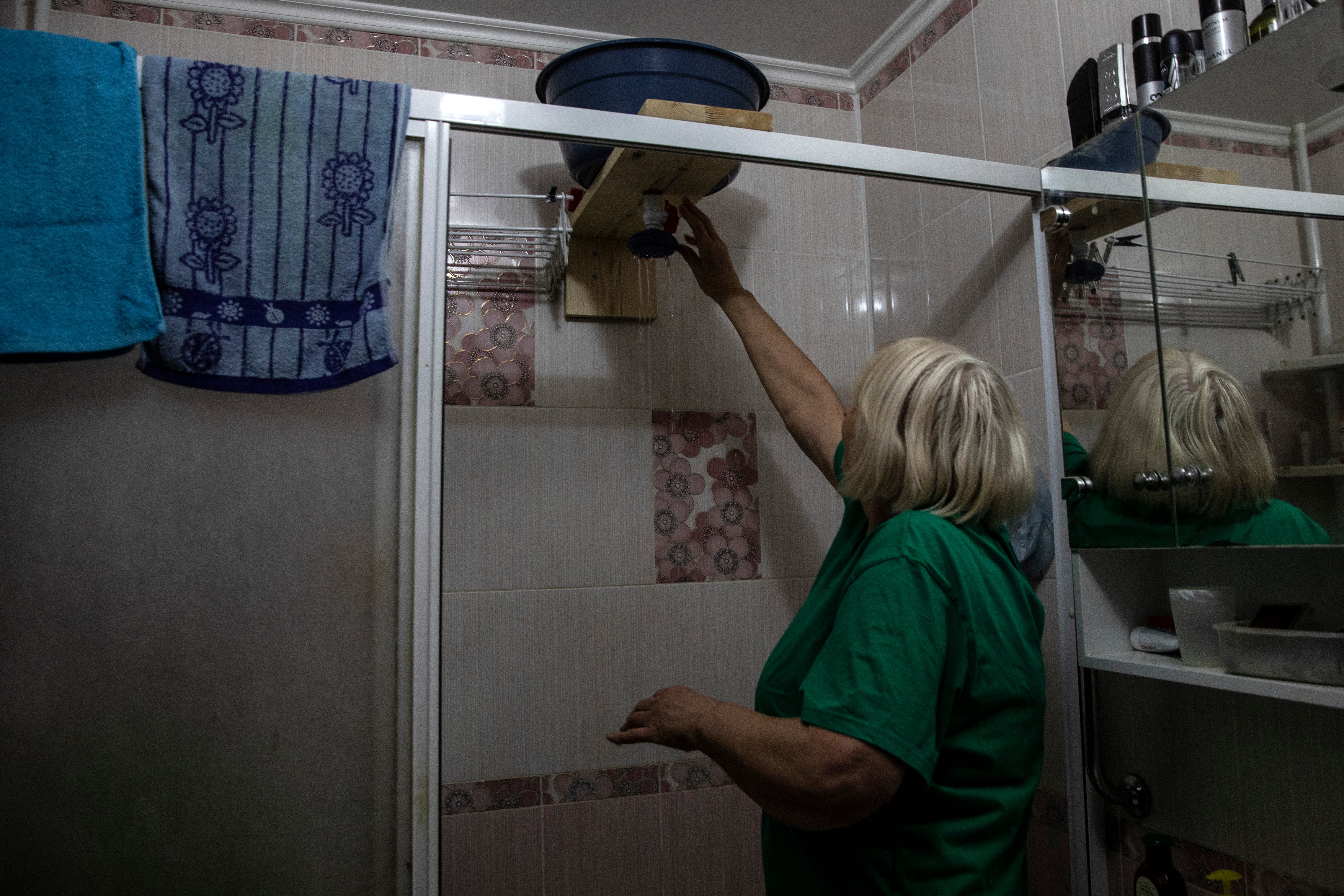 Valentyna Donchenko with the improvised shower her husband built so they can bathe with clean water