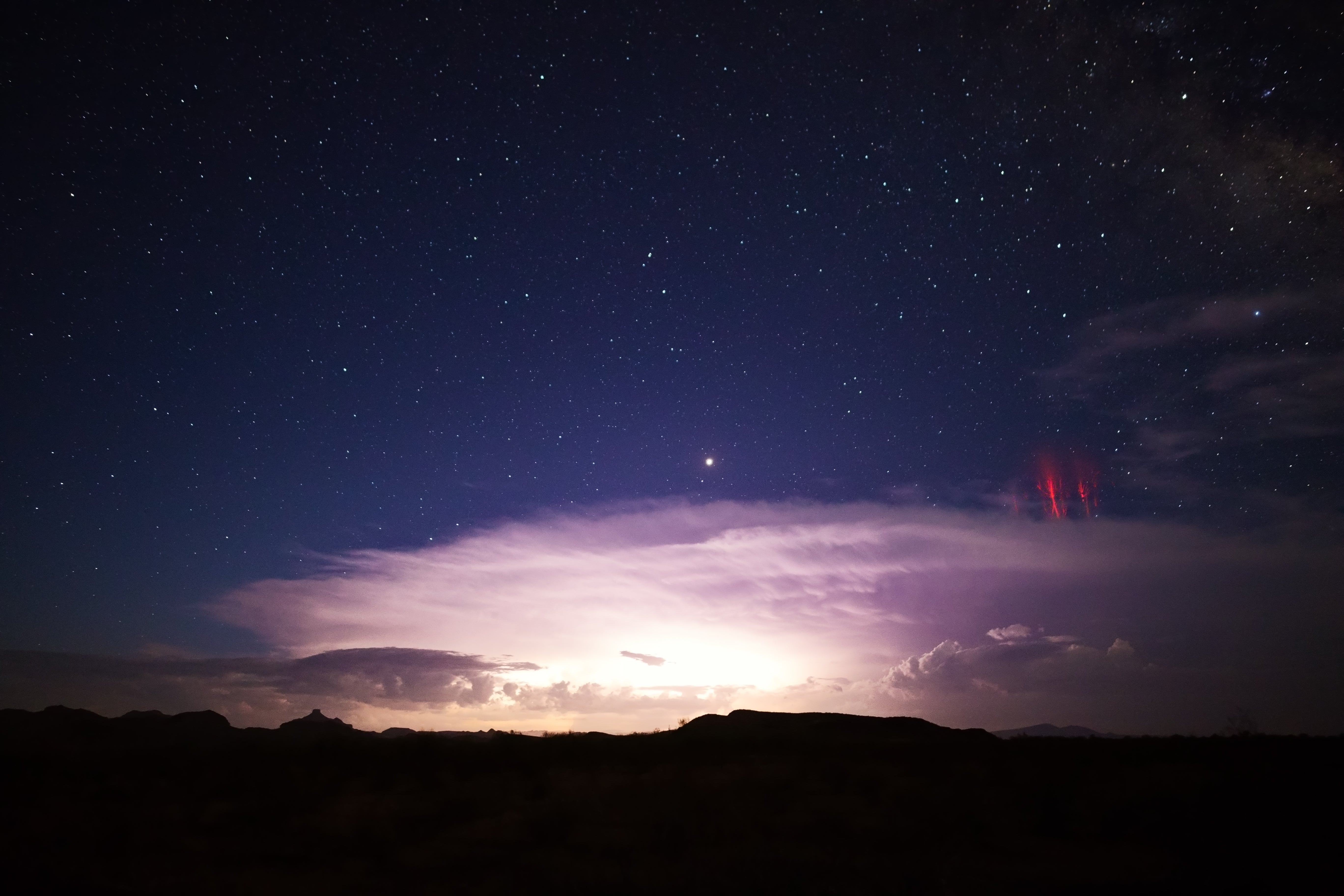 Sprite lightning, the reddish streaks on the right, as seen over a thunderstorm in Arizona. The phenomenon was also seen this week around the outer edges of Tropical Storm Nicole
