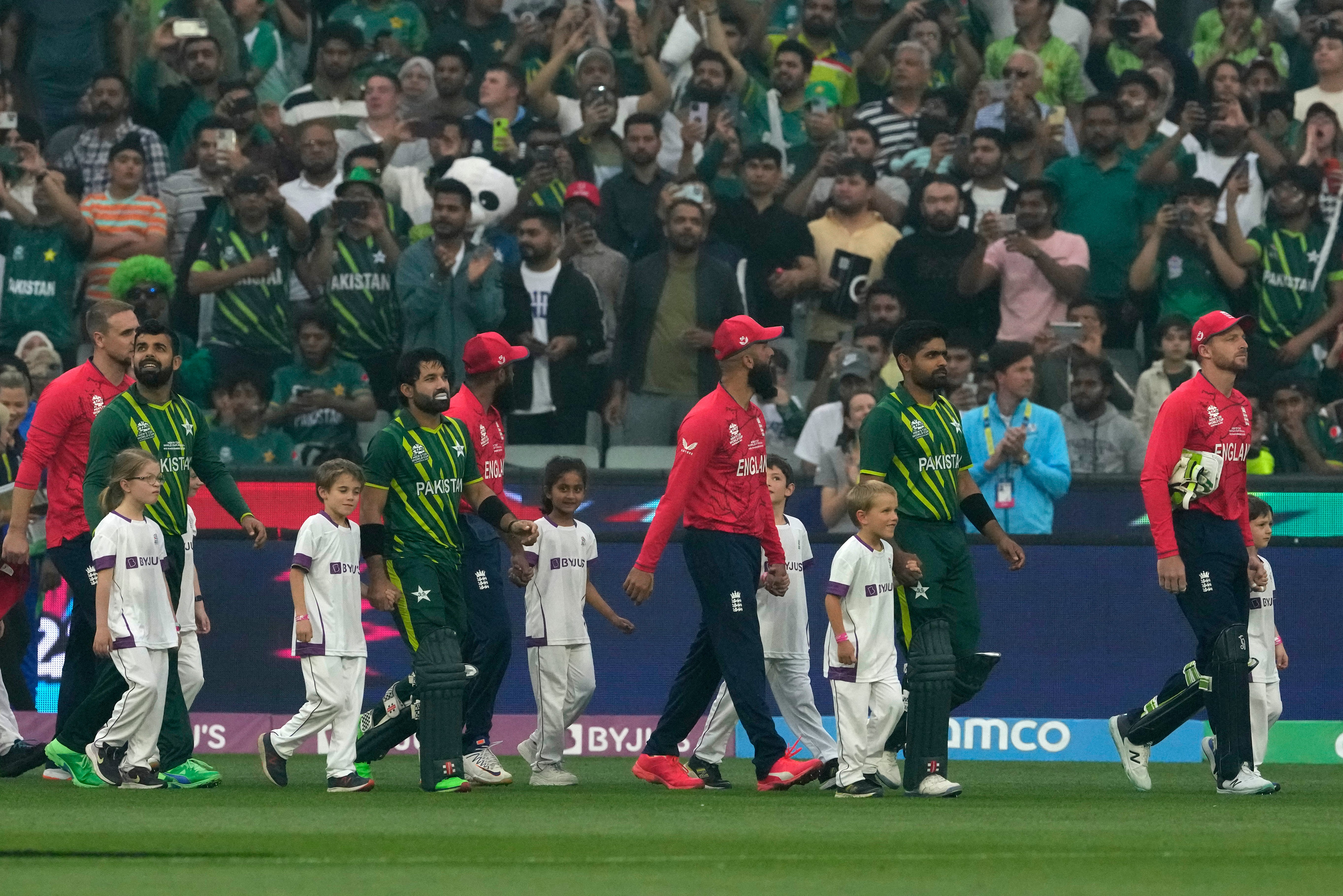 Pakistan and England players walk into the field