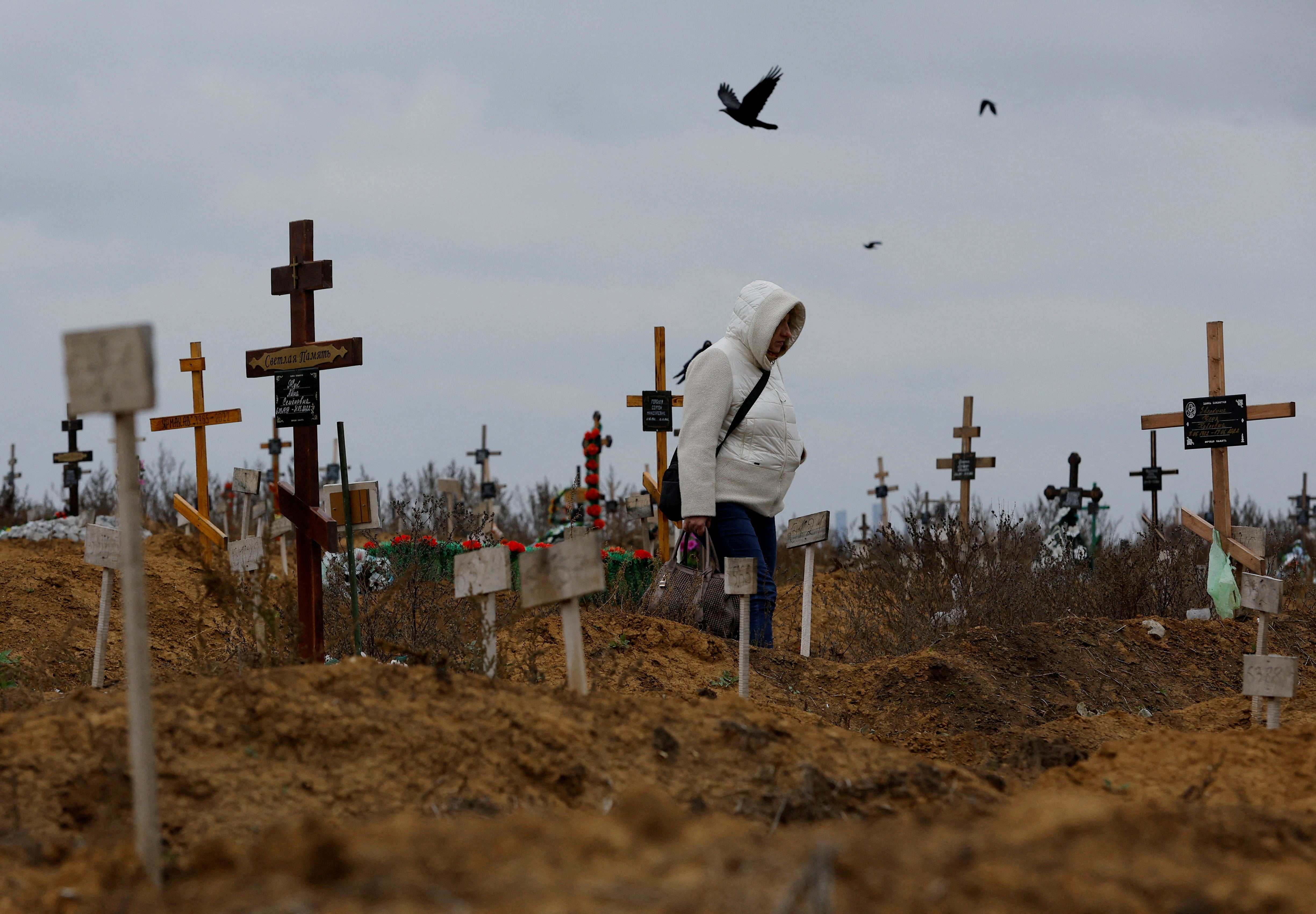 A woman visits a cemetery, in the course of Russia-Ukraine conflict in the settlement of Staryi Krym outside Mariupol, Russian-controlled Ukraine, November