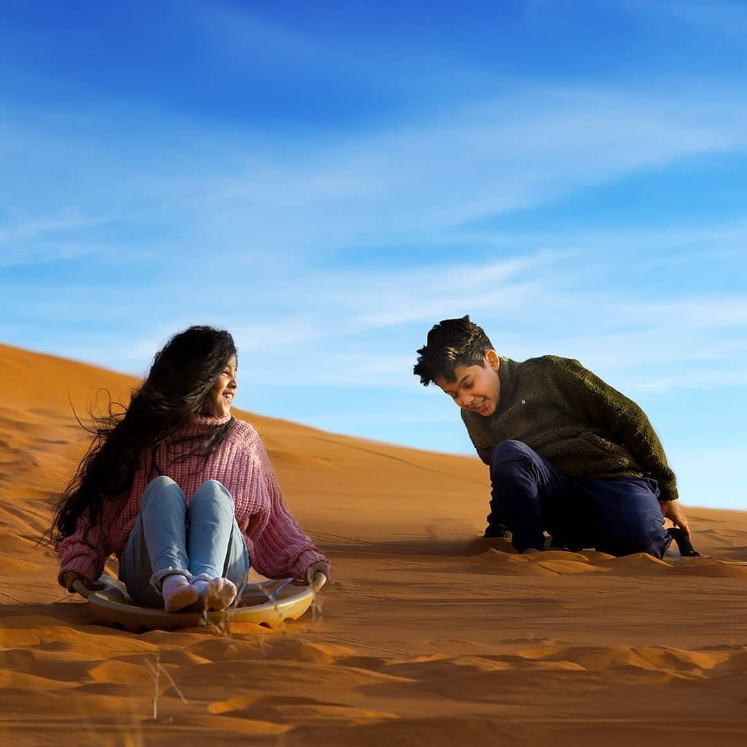 Kids will love sandsledding down desert dunes