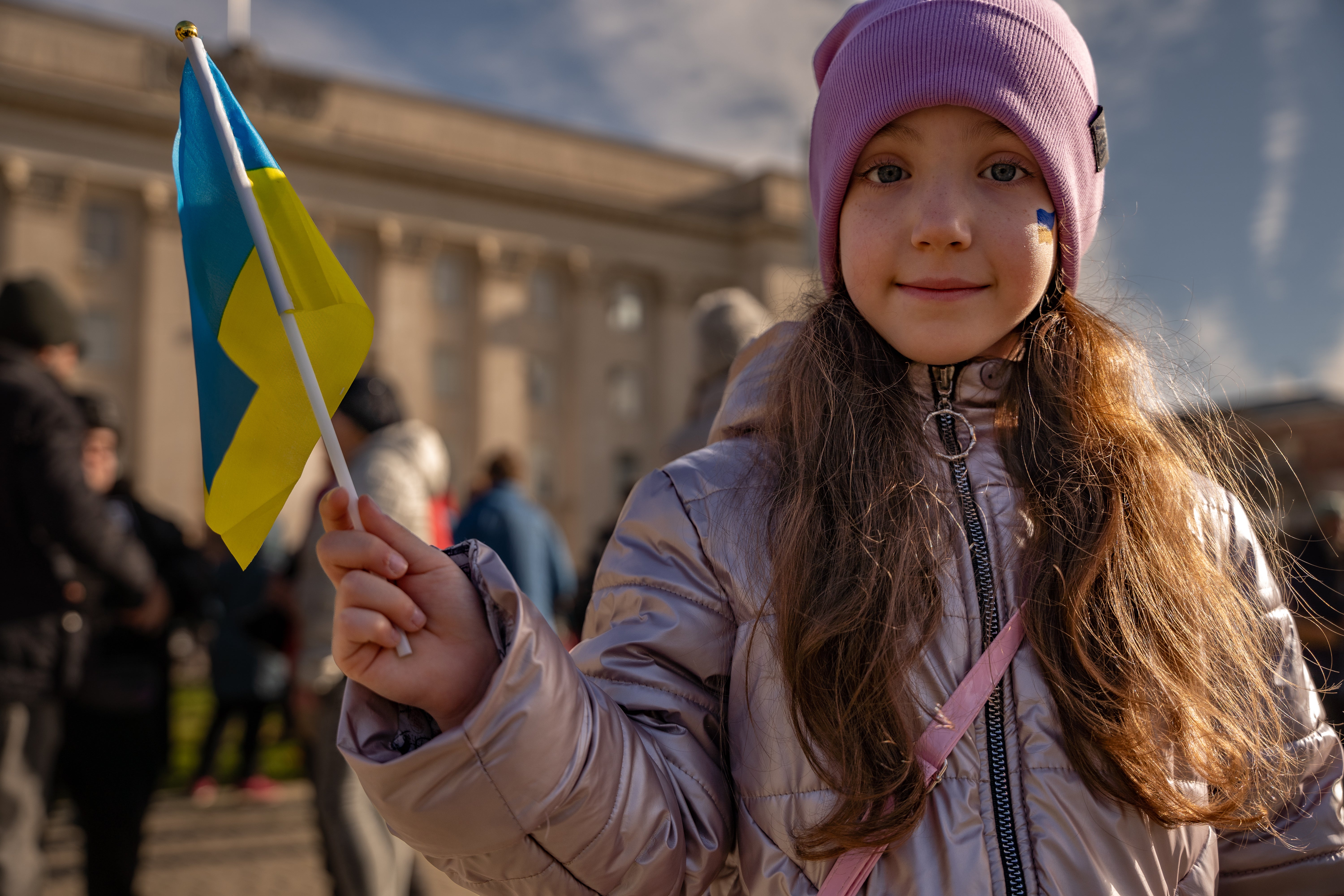 A girl waves a Ukrainian flag in celebration after months of Russian occupation