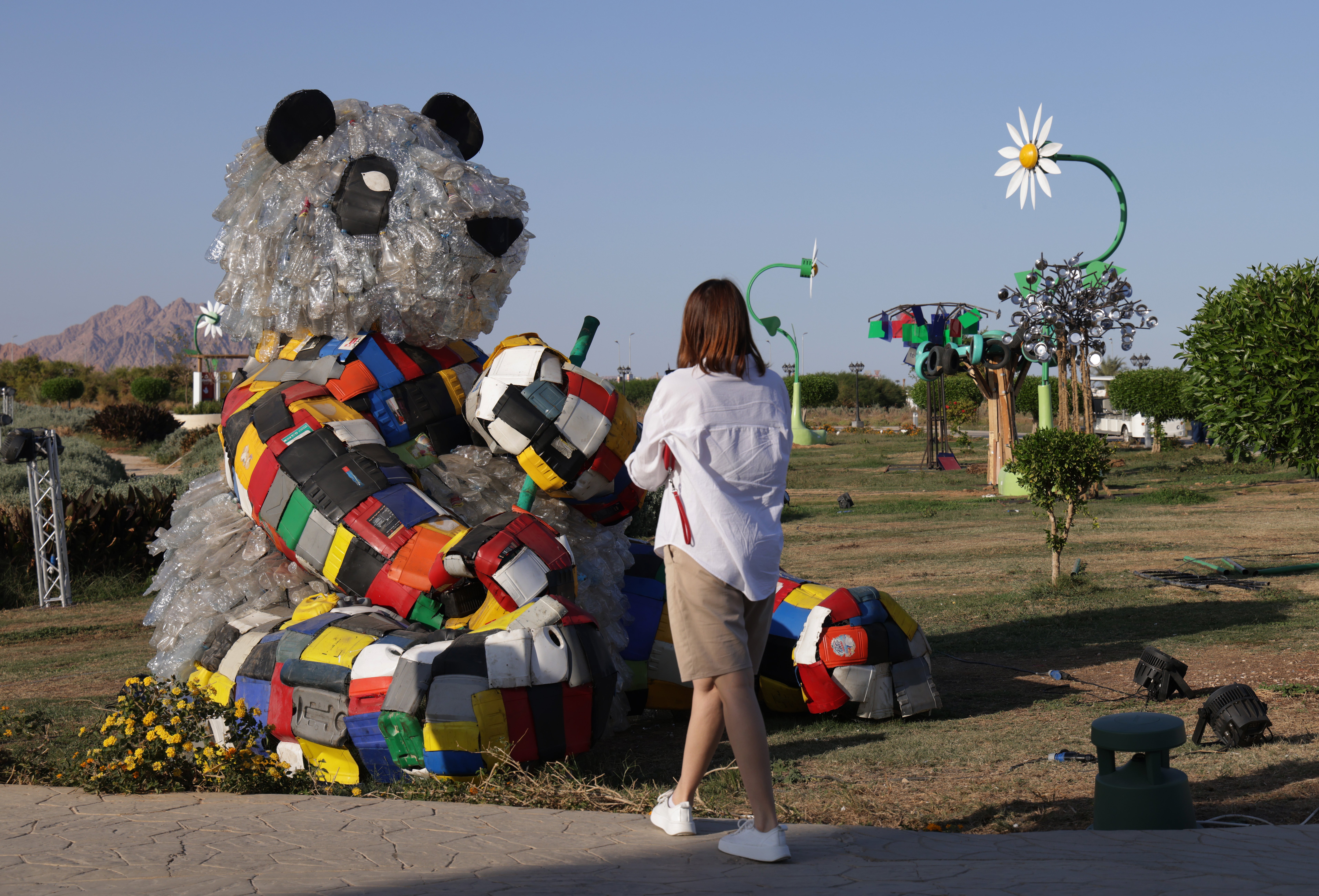 A visitor photographs a bear made of plastic waste in the Green Zone of the Cop27 climate conference