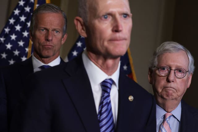 <p>Sen Rick Scott stands in the foreground while Sens John Thune and Mitch McConnell stand behind him</p>