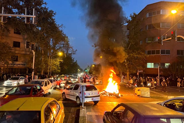 <p>A police motorcycle burns during a protest over the death of Mahsa Amini in central Tehran</p>