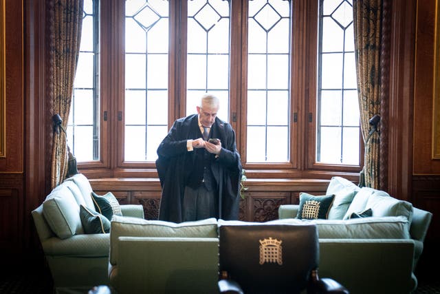 Speaker of the House of Commons Sir Lindsay Hoyle uses a mobile phone in his office in the Palace of Westminster (Stefan Rousseau/PA)