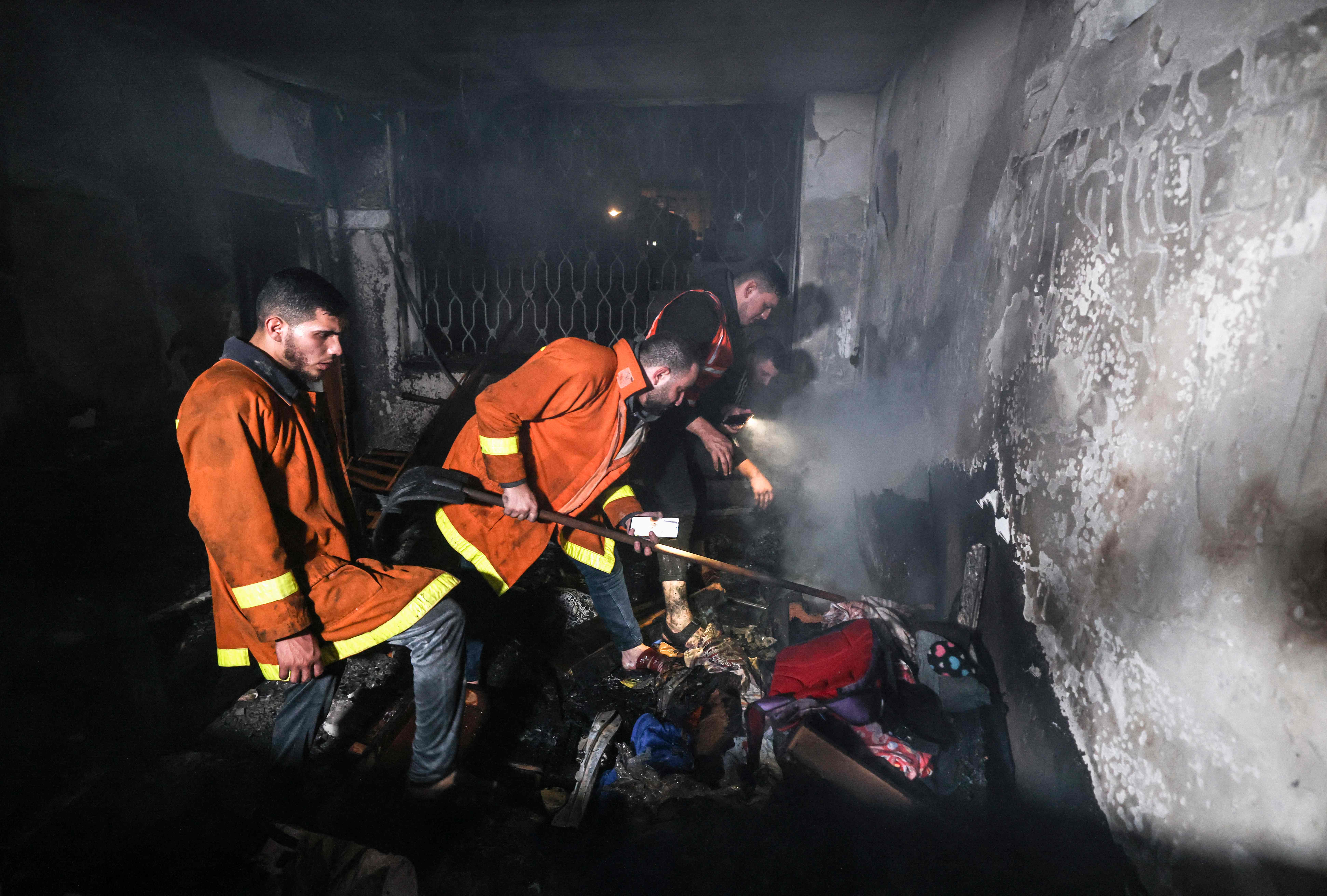 Palestinian firefighters extinguish a fire which broke out in one of the apartments in the Jabalia refugee camp in the northern Gaza strip