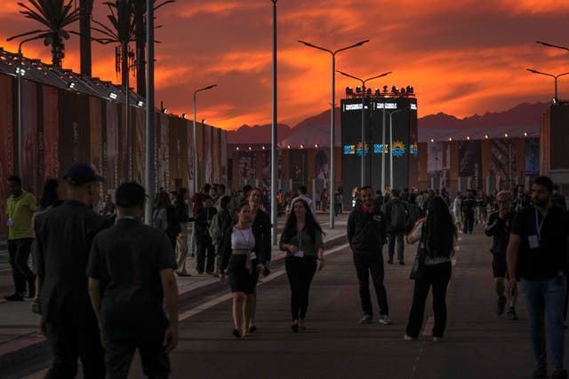 <p>Attendees walk at the Cop27 United Nations climate summit at sunset</p>