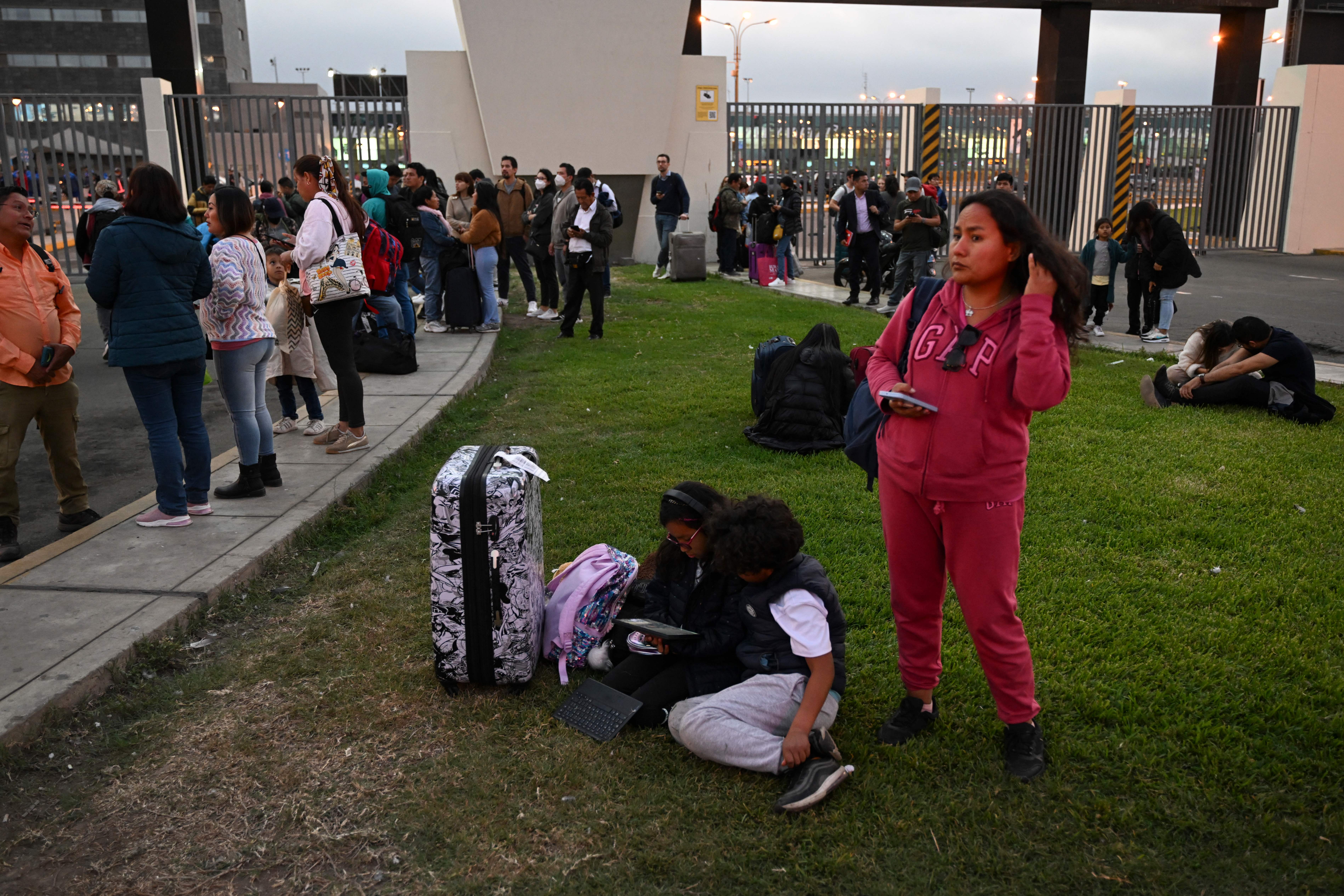 People who lost their flights remain outside the closed Jorge Chavez International Airport after the accident of the LA2213 flight in Lima, on 18 November 2022