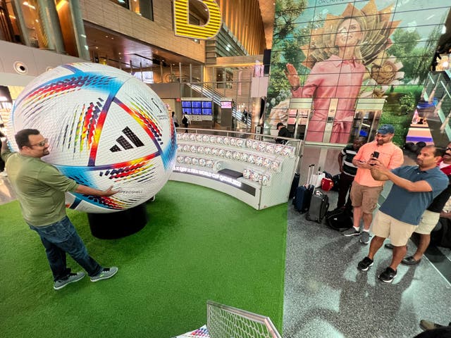 <p>Global gathering: Fans with a giant football at Hamad International Airport in Doha</p>