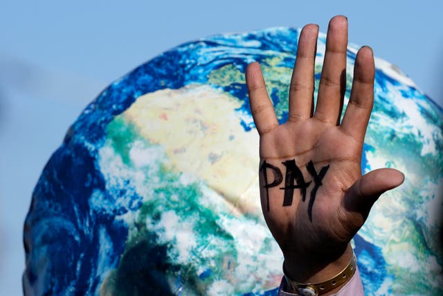 <p>An activist’s hand reads ‘pay’ for compensation for loss and damage at Cop27. The summit came to an end on Sunday </p>