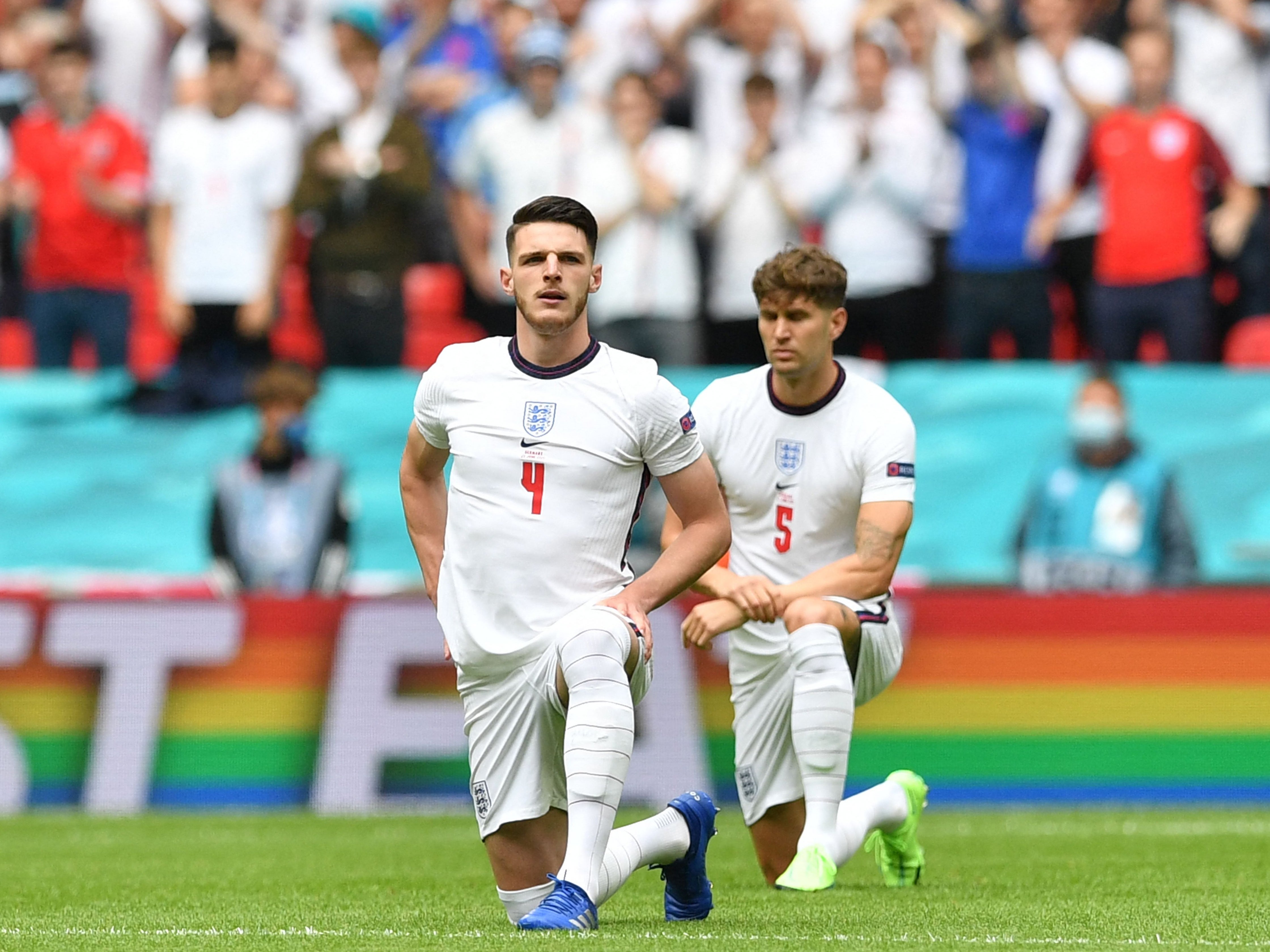 Declan Rice and John Stones take the knee while representing England
