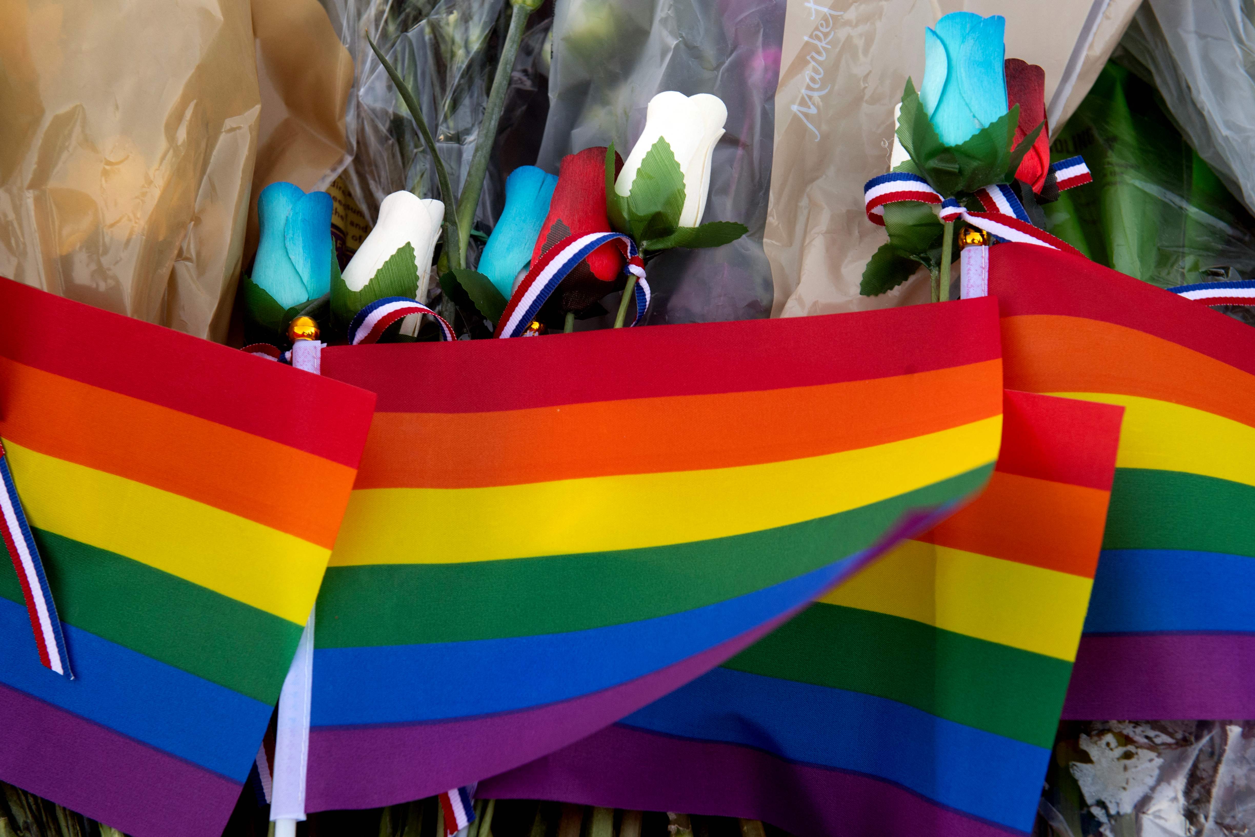 Mourners placed Pride flags and flowers at a makeshift memorial
