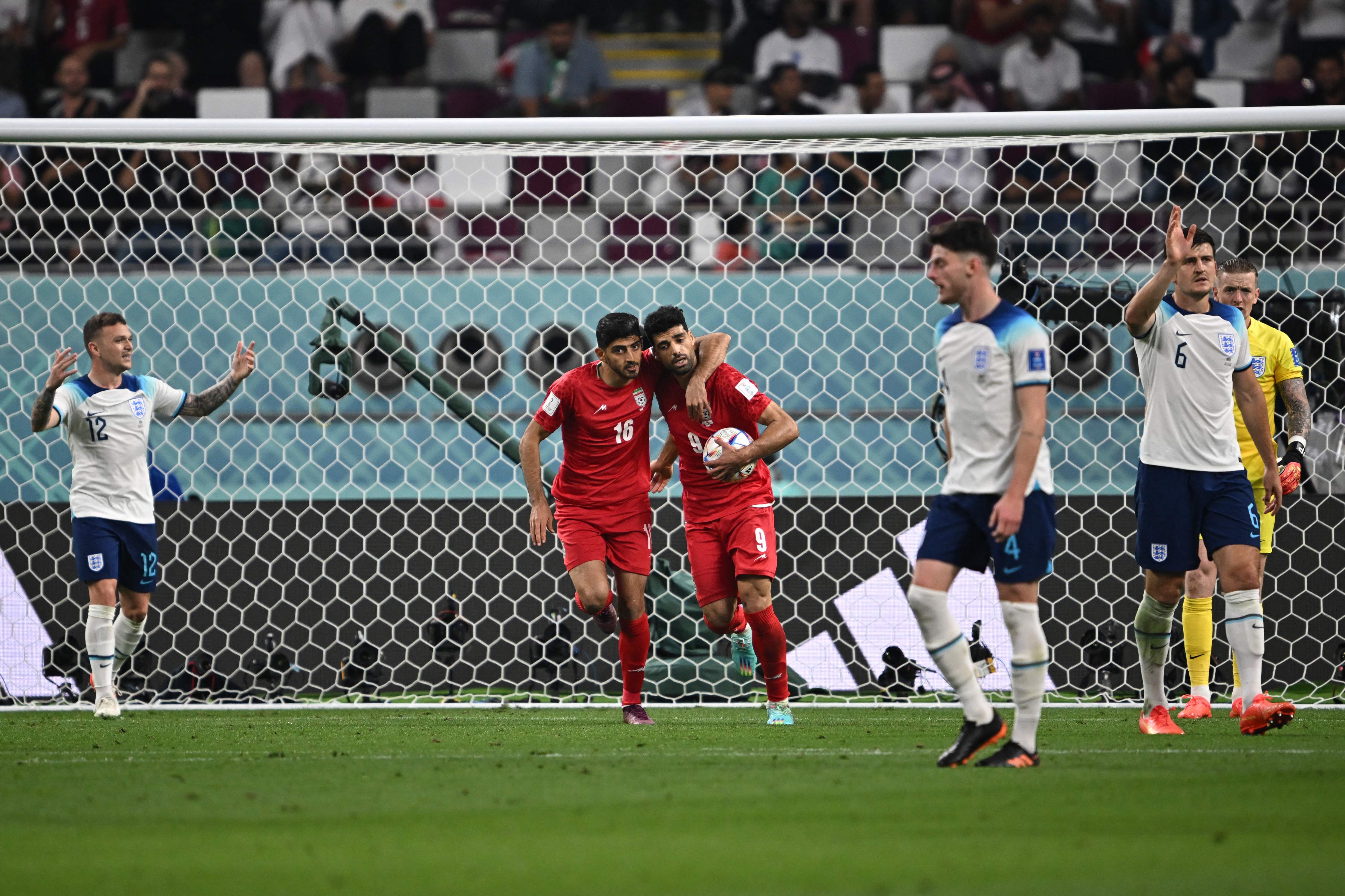 As Taremi celebreates, the England players around him react