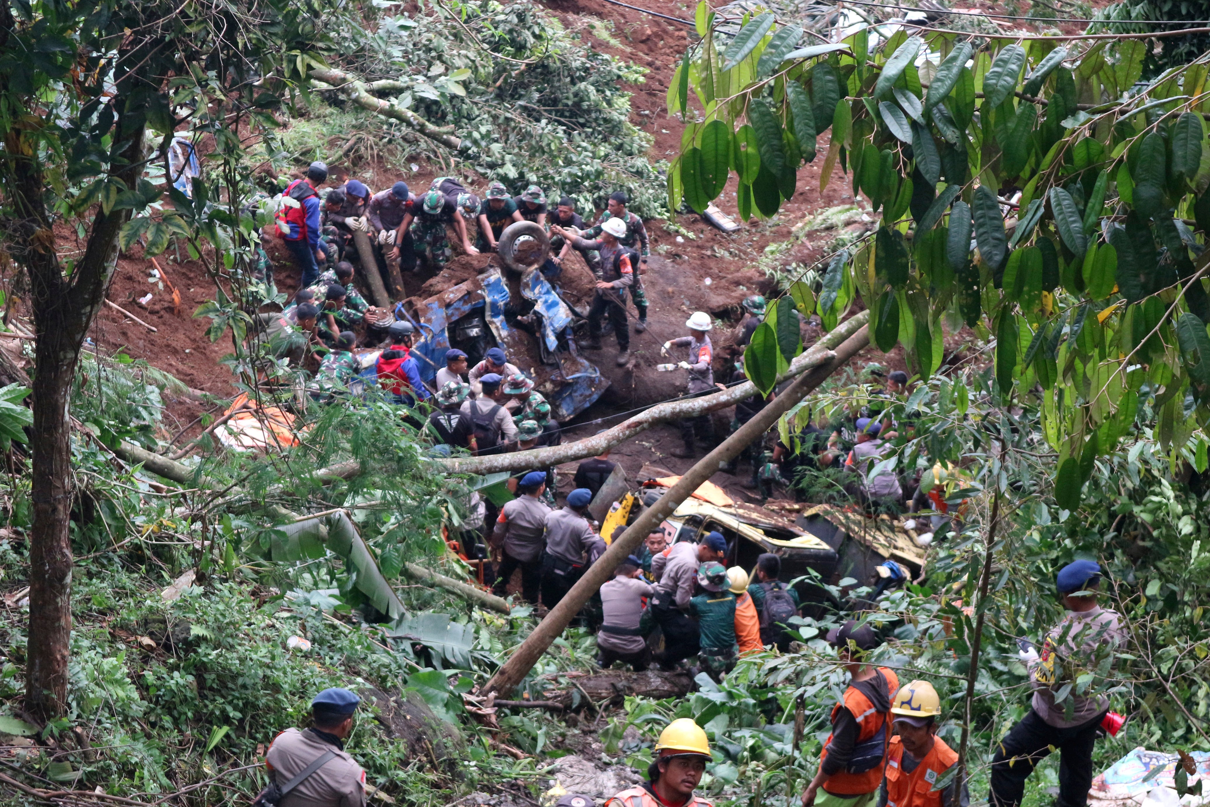 Rescuers remove the wreckages of vehicles damaged in an earthquake-triggered landslide in Cianjur