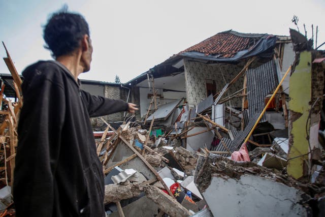 <p>A local stands near houses damaged after an earthquake in Cianjur</p>