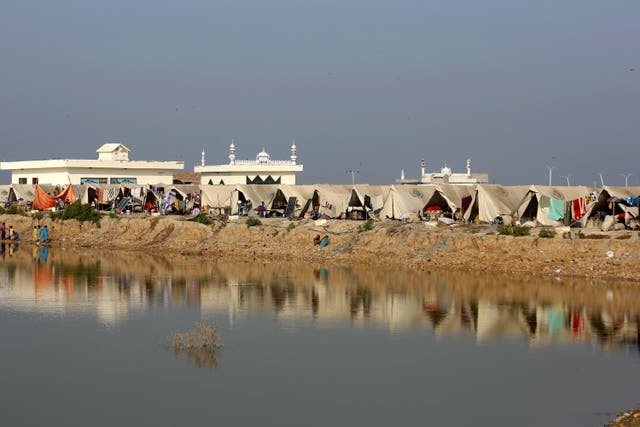 <p>People take refuge in a relief camp setup on a higher ground surrounded by floodwaters, in Jaffarabad, a flood-hit district of Baluchistan province, Pakistan</p>