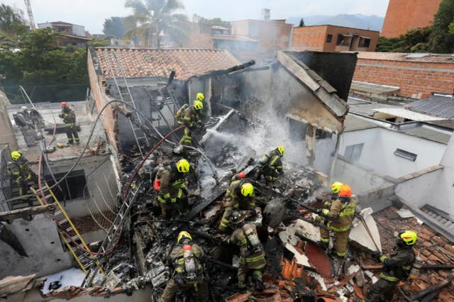 <p>Firefighters at the scene of the crash in Medellin, Colombia where an aircraft carrying eight people crashed and killed all on board</p>