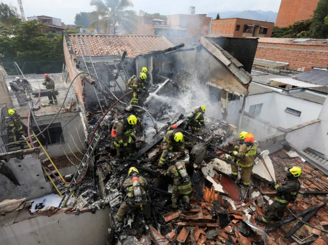 <p>Firefighters at the scene of the crash in Medellin, Colombia where an aircraft carrying eight people crashed and killed all on board</p>
