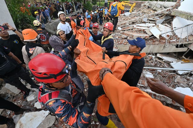 <p>Rescue workers carry the body of a victim in Cianjur on 22 November 2022, following a 5.6-magnitude earthquake</p>