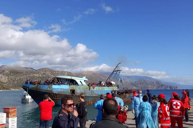 <p>A boat carrying about 400 migrants pulled by a fishing boat during a rescue opperation arrive at Palaiochora harbour, at the island of Crete </p>