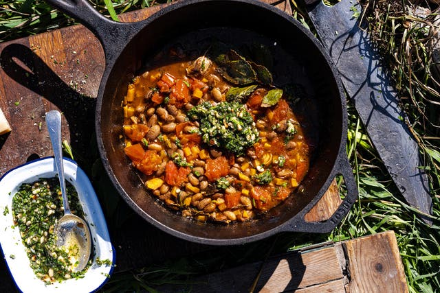 <p>Carrot top pesto boosts the flavour of this borlotti bean stew, while also saving waste </p>