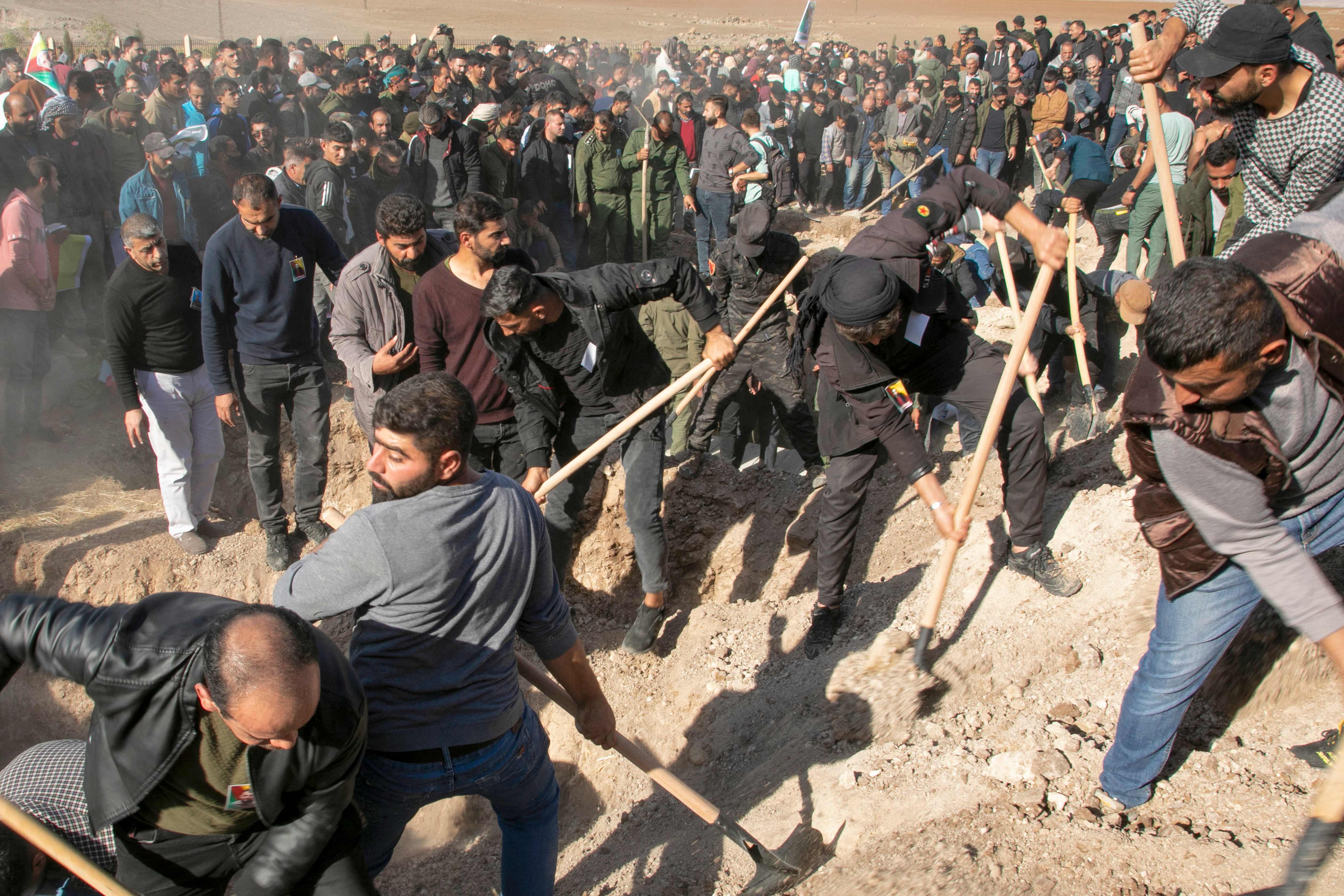 Syrian Kurds dig the graves of 11 people killed in Turkish air strikes
