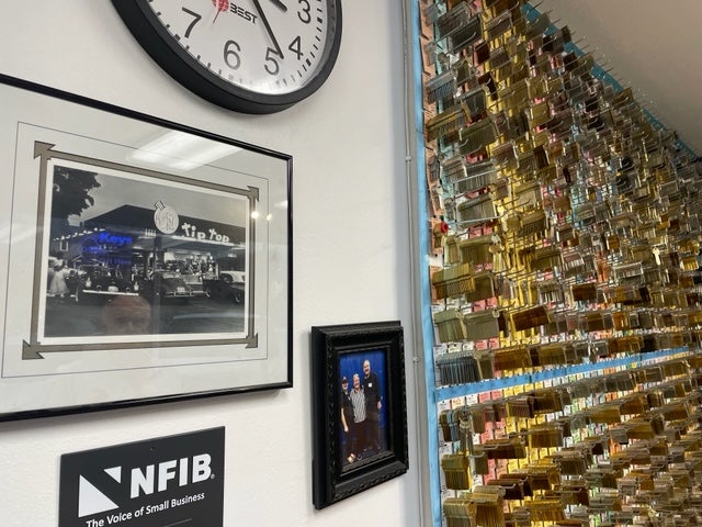 The Lock Shop is located in a building which previously housed the Tip Top Cafe, displayed in a photo next to rows of keys; the eatery was the site of a 1969 unsolved slaying that was the town’s most infamous murder until last week