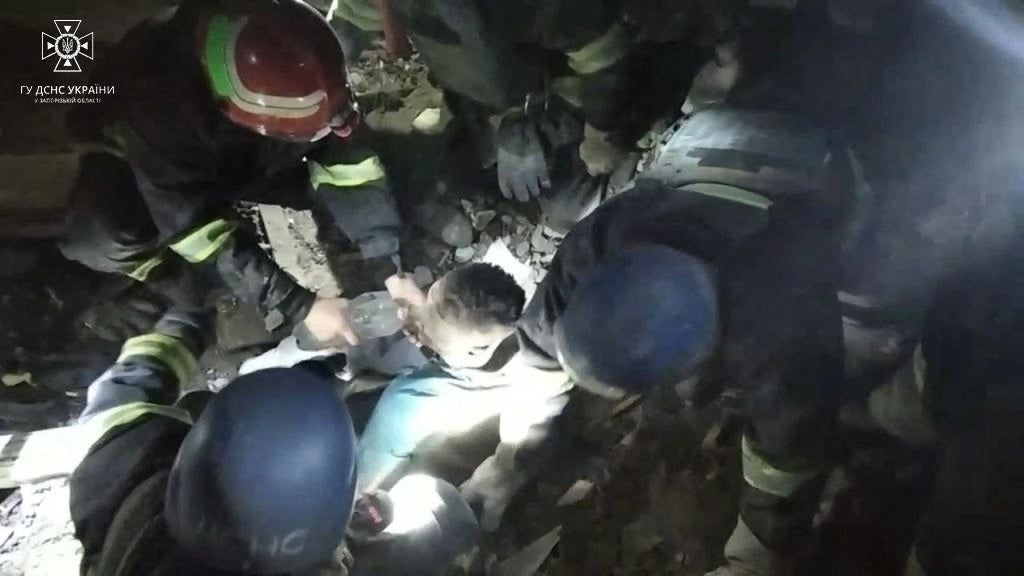 Ukrainian rescuers remove a doctor from the rubble of the hospital maternity ward