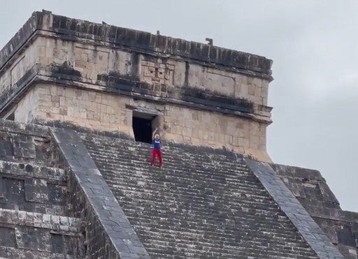 <p>Tourist appears to mock the 'no climbing' rule with a little dance at the top</p>