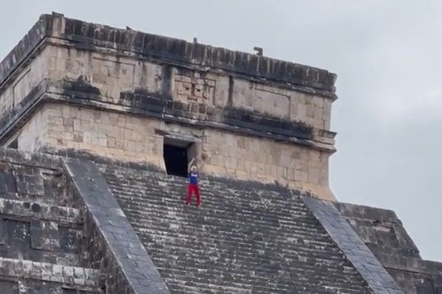 <p>Tourist appears to mock the 'no climbing' rule with a little dance at the top</p>
