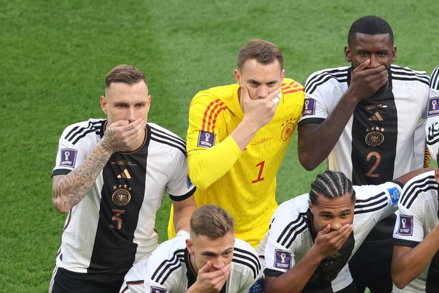 <p>German players cover their mouths in protest before the game with Japan </p>