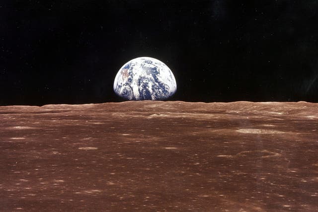 <p>A view of Earth over the lunar horizon</p>