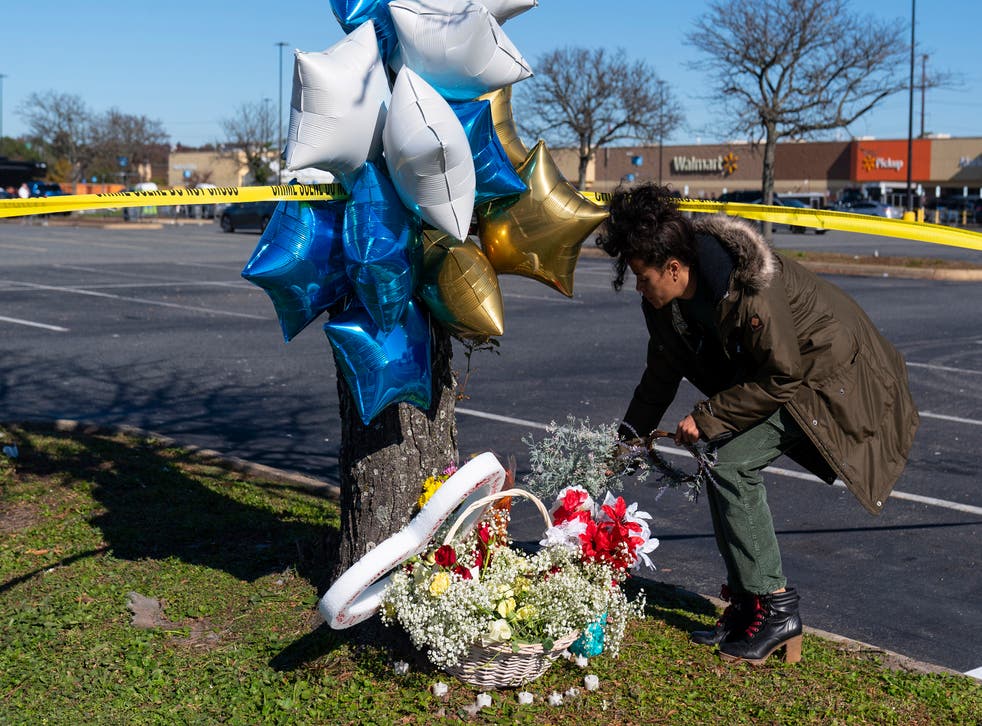 <p>Shyleana Sausedo-Day, from Portsmouth, Virginia, places flowers near the scene of the Walmart mass shooting on 23 November 2022</p>