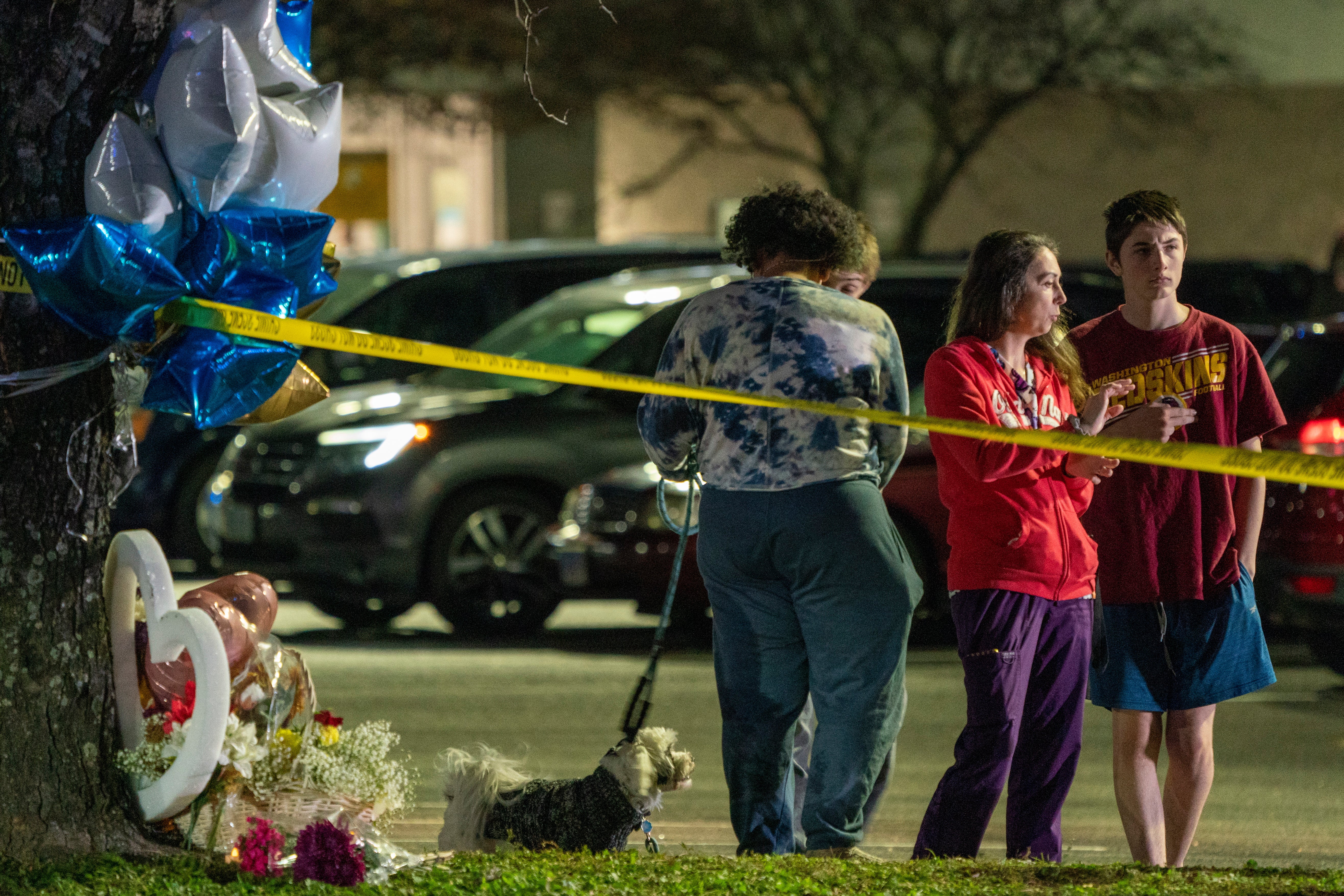 A group gathers near a makeshift memorial outside a Walmart in Virginia where an employee killed six people