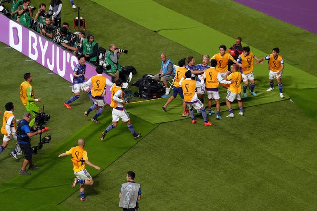 Japan’s Takuma Asano (number 18) is mobbed by his team-mates after scoring his country’s second goal in their victory against Germany (Nick Potts/PA)